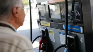 Cliente diante de bomba de diesel em posto de combustível, ilustrando o reajuste do ICMS dos combustíveis