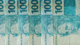 Cédulas de R$ 100 enfileiradas, ilustrando a alíquota de referência da CBS calculada pelo TCU