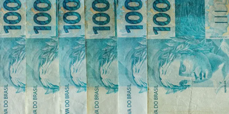 Cédulas de R$ 100 enfileiradas, ilustrando a alíquota de referência da CBS calculada pelo TCU