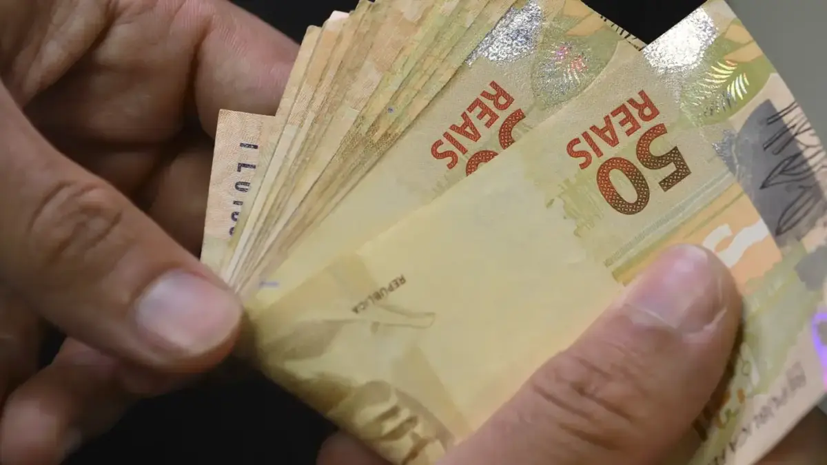Mãos contam notas de R$ 50, ilustrando as estatísticas de pagamentos de varejo do Banco Central no primeiro semestre de 2026